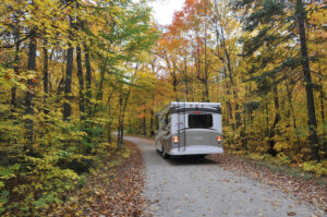 Shot of the back of an RV driving through fall foliage